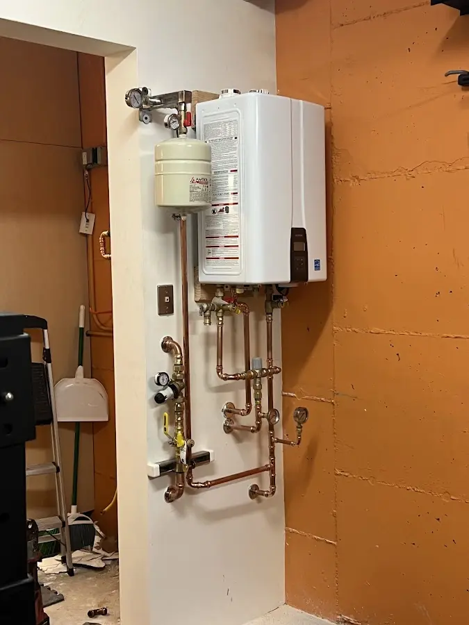 Plumbing technician inspecting water heater connections in Buchanan
